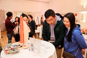 Guests browsing display tables at an indoor event space.