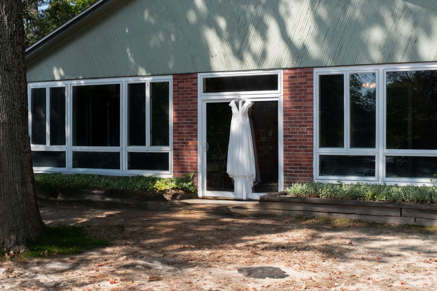 White wedding dress hanging outdoors at Wye Island in Queenstown Maryland, a wedding venue on a budget.
