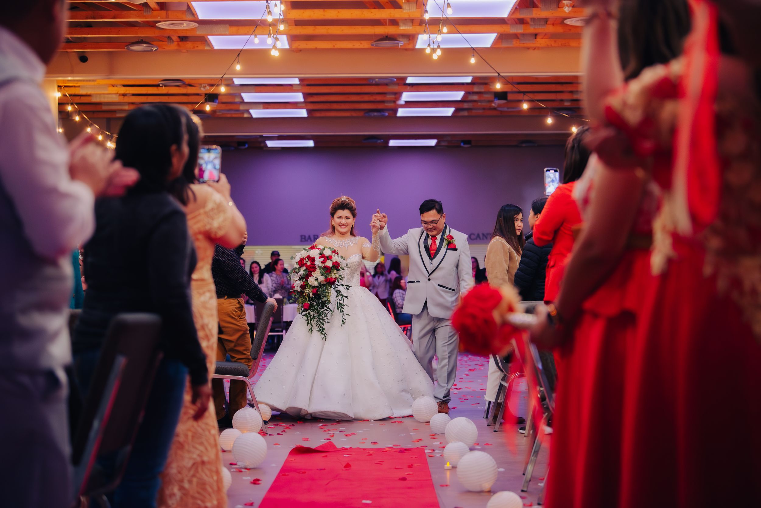 Married couple being welcomed by their guests in the reception hall.