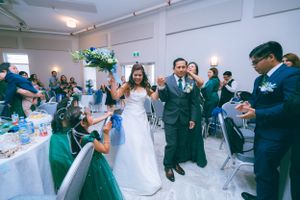 Married couple being welcomed by their guests in the reception hall.