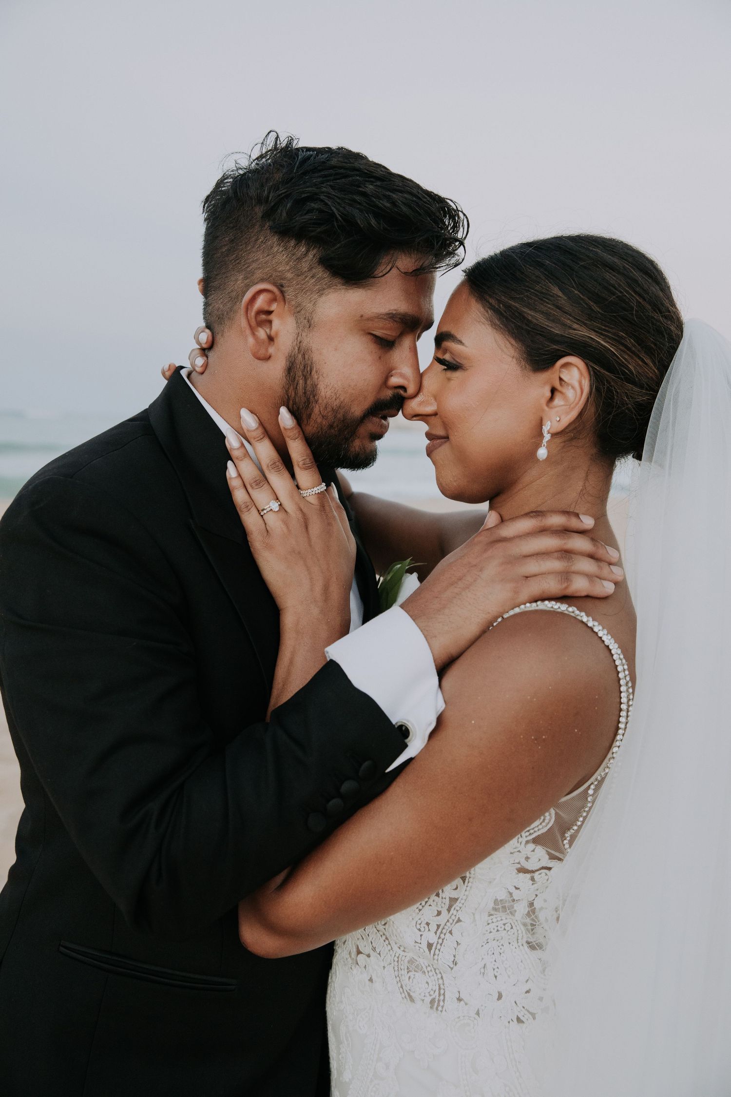 Intimate wedding couple sharing a romantic moment on a beach during their destination wedding photoshoot.