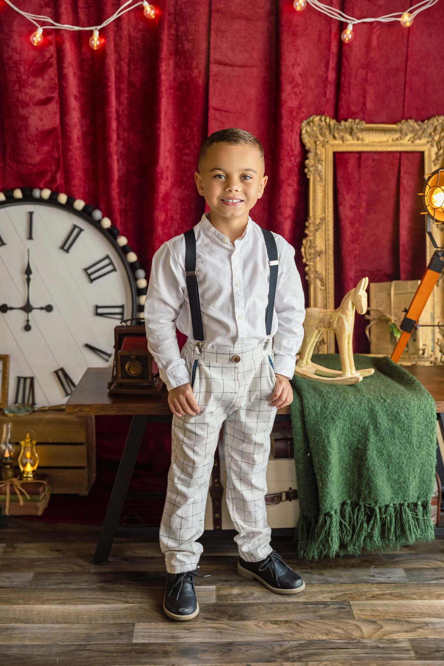 Little boy dressed as a gentlemen with suspenders and dress pants in a studio session