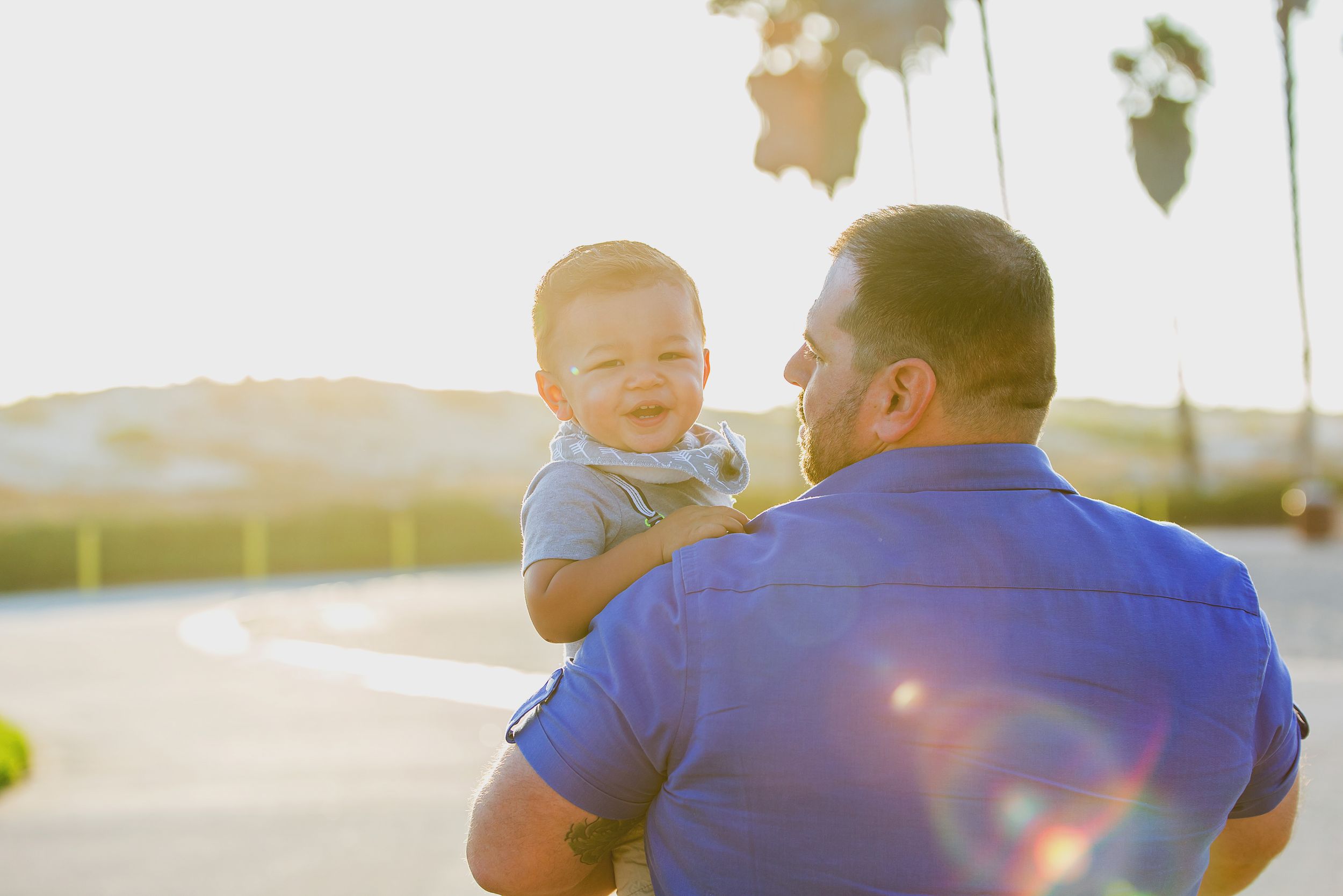 A joyful moment between parent and child captured in golden sunlight.