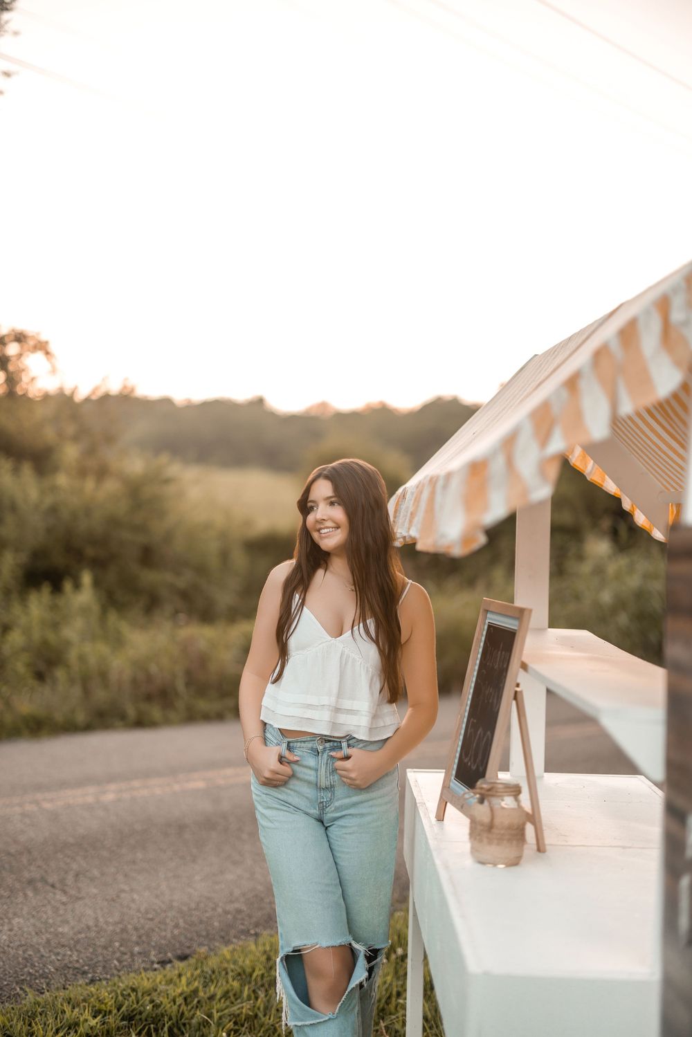 White food cart with striped awning at sunset on a country road with a casual summer style.