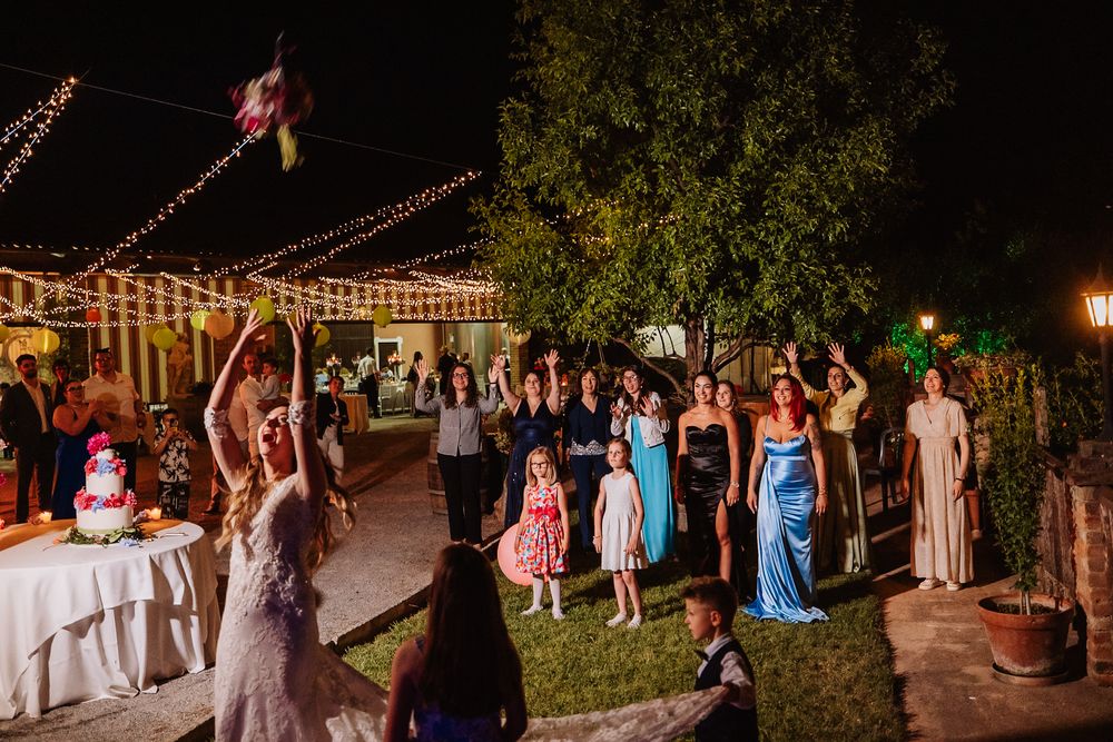 Wedding guests dance together on an outdoor patio during evening reception party.
