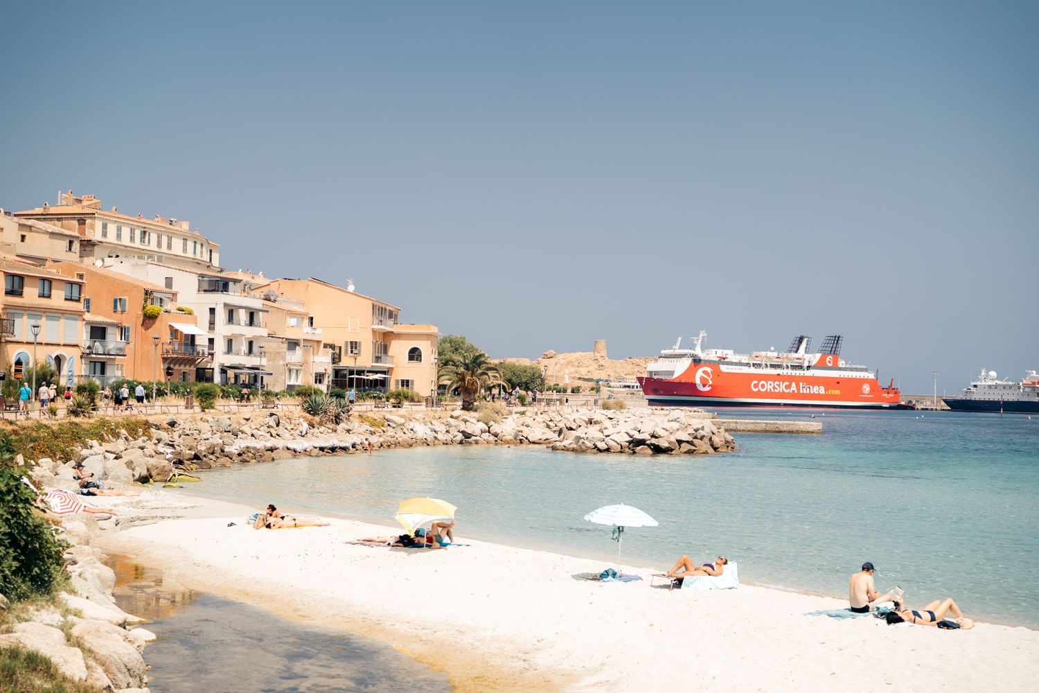 plage de l'île rousse avec ferry en arrière plan