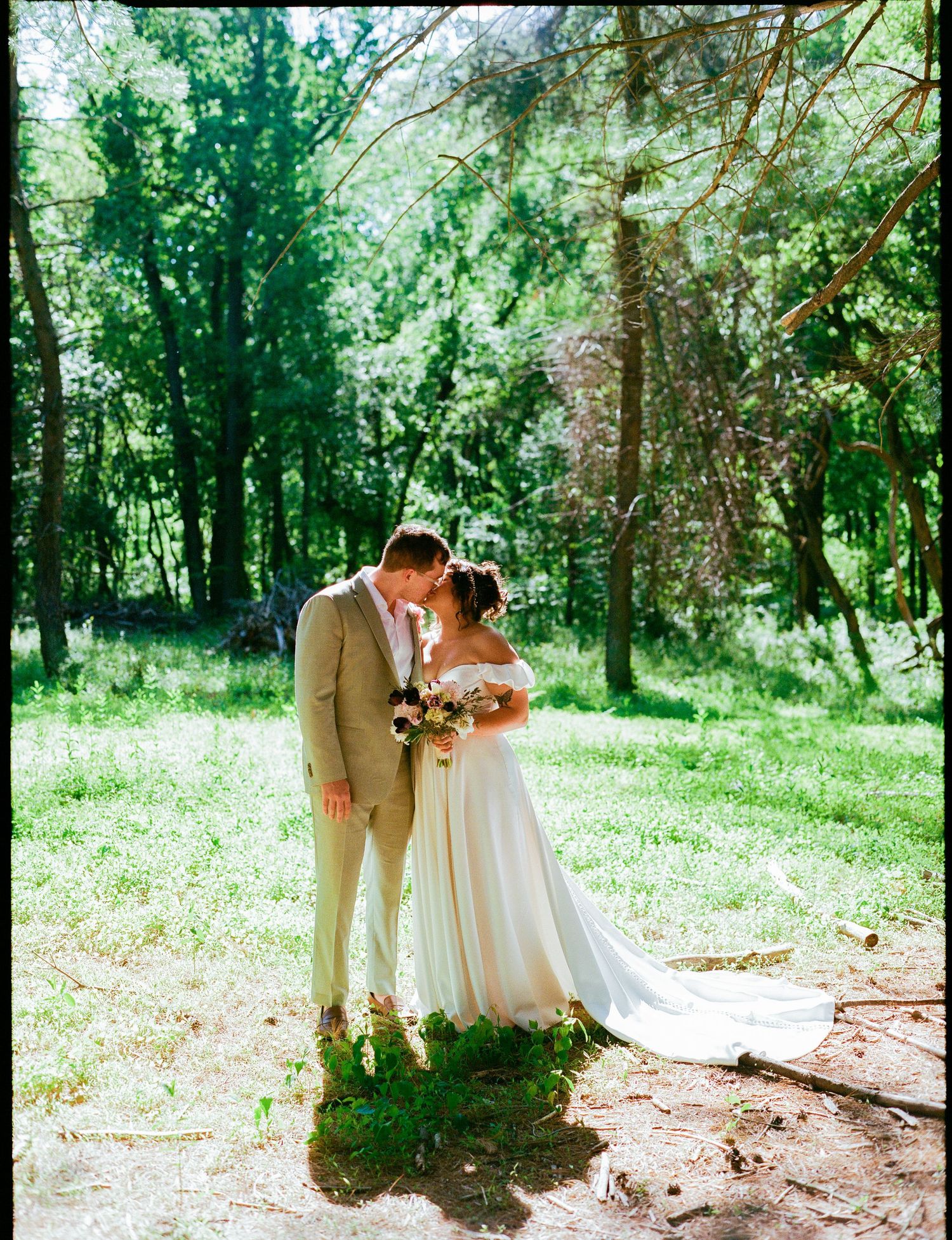 A romantic outdoor wedding photo set featuring a couple embracing among sunlit trees in a woodland setting.