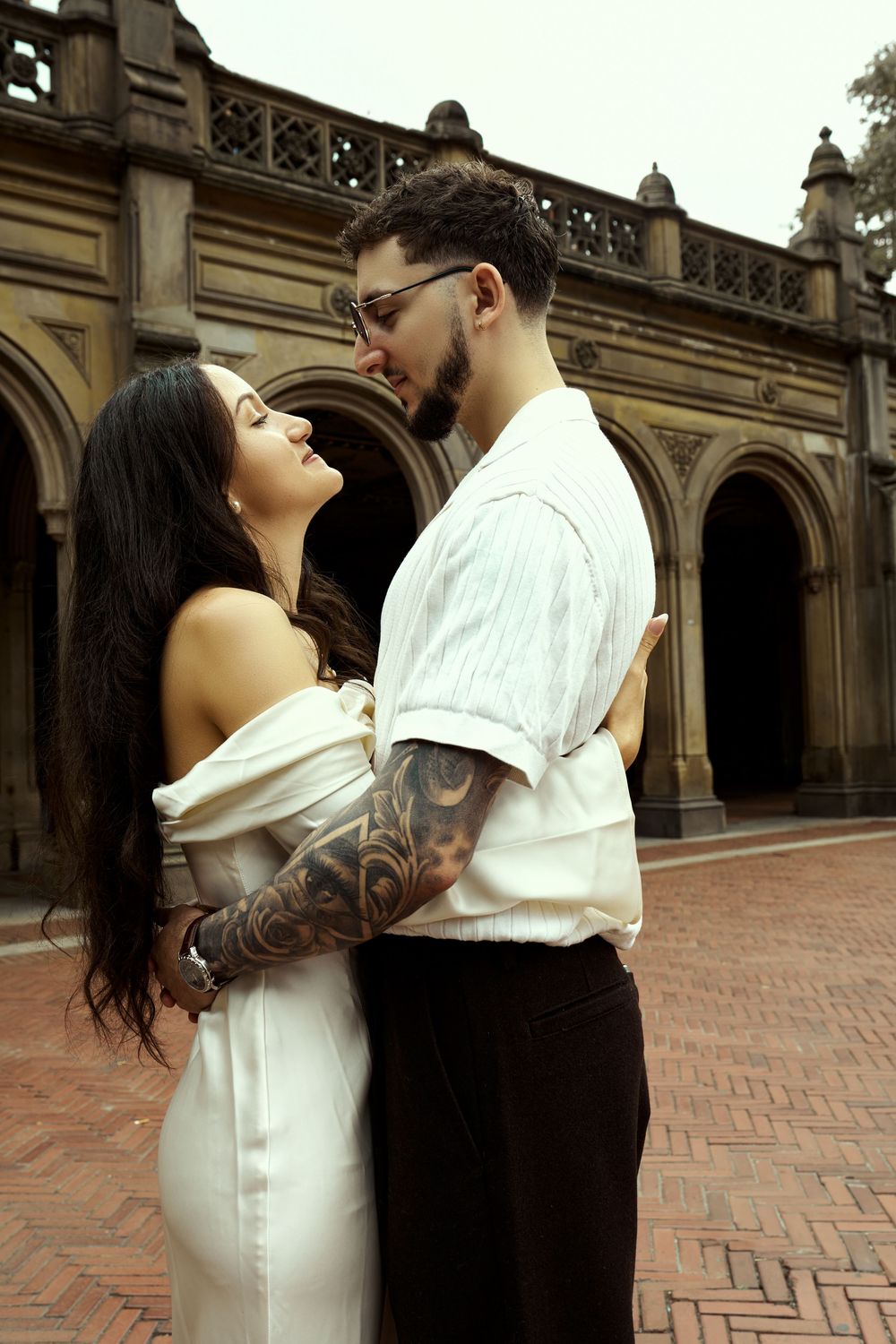Intimate engagement portrait against ornate architectural backdrop.