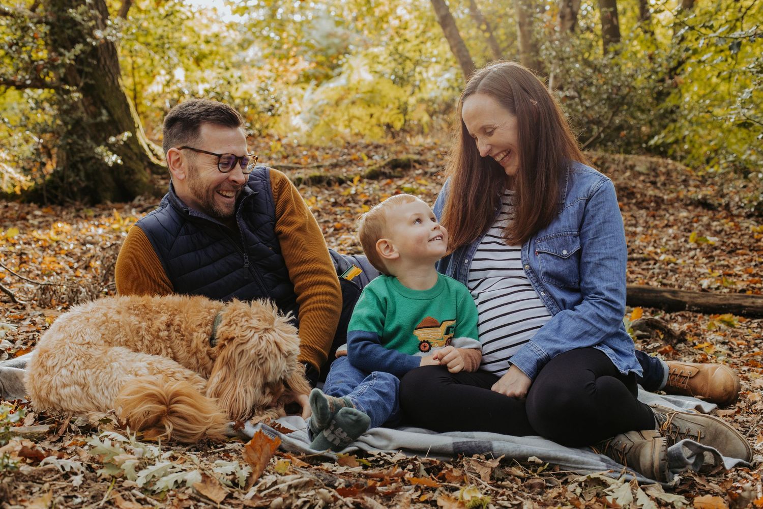 A family and dog surrounded by autumn colours and leaves during a an autumn mini session in bedfordshire/Milton Keynes