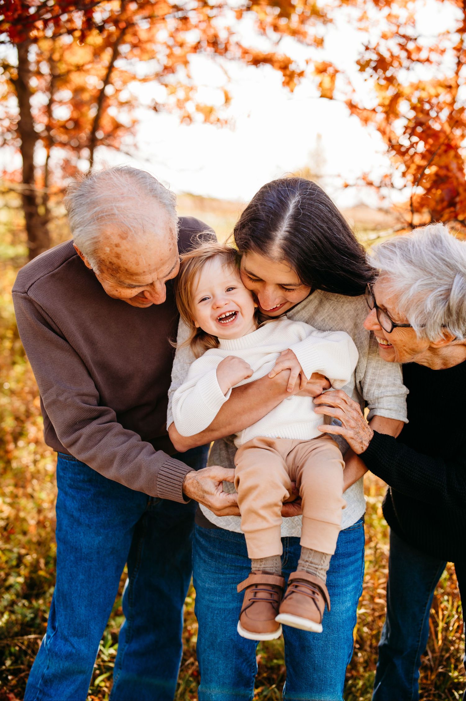 A heartwarming multi-generational family moment captured in warm autumn sunlight.
