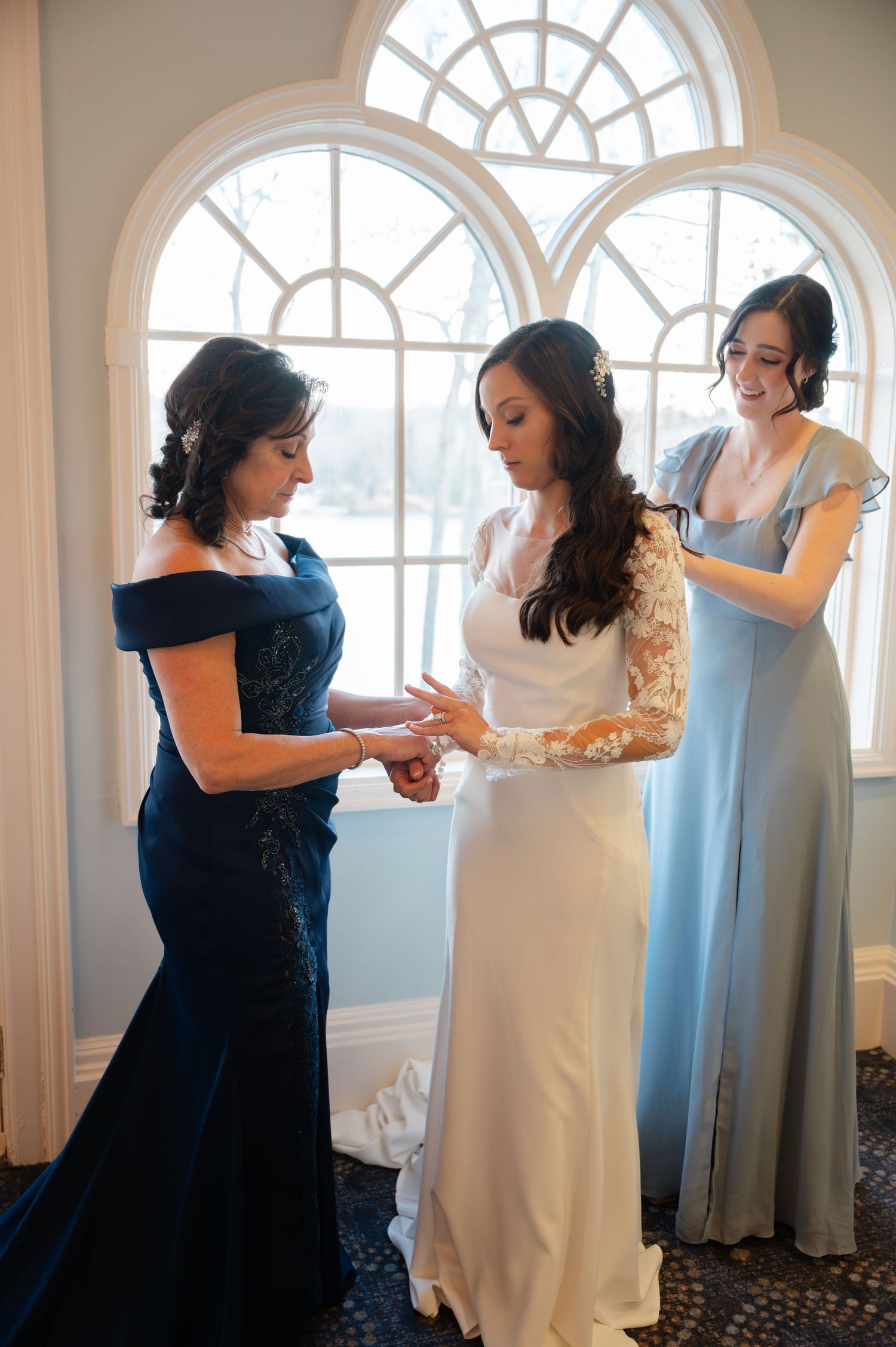 A mother and maid of honor help a bride getting ready before her wedding at the Waterview in CT.