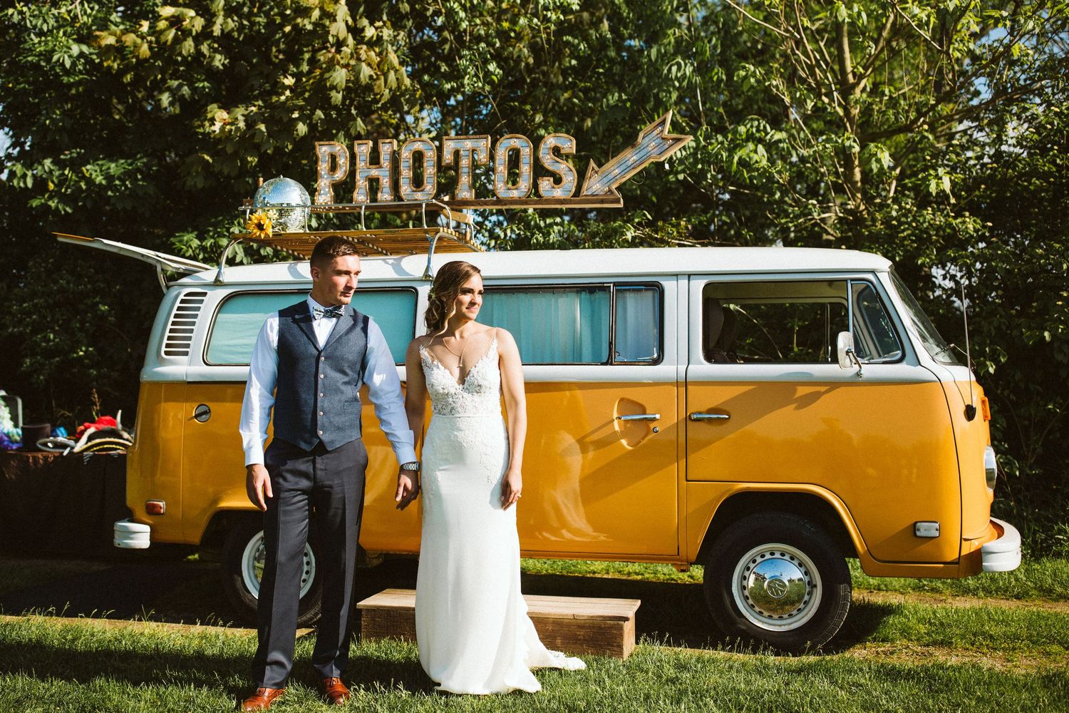 Vintage yellow VW bus parked outdoors serves as a stylish wedding photo backdrop.