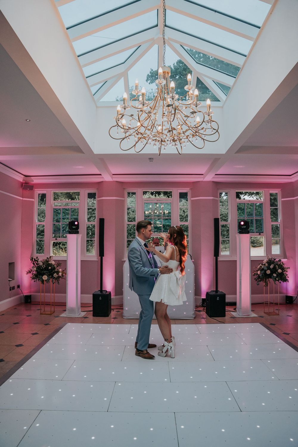 Newlyweds dancing at Rockbeare Manor reception under chandelier