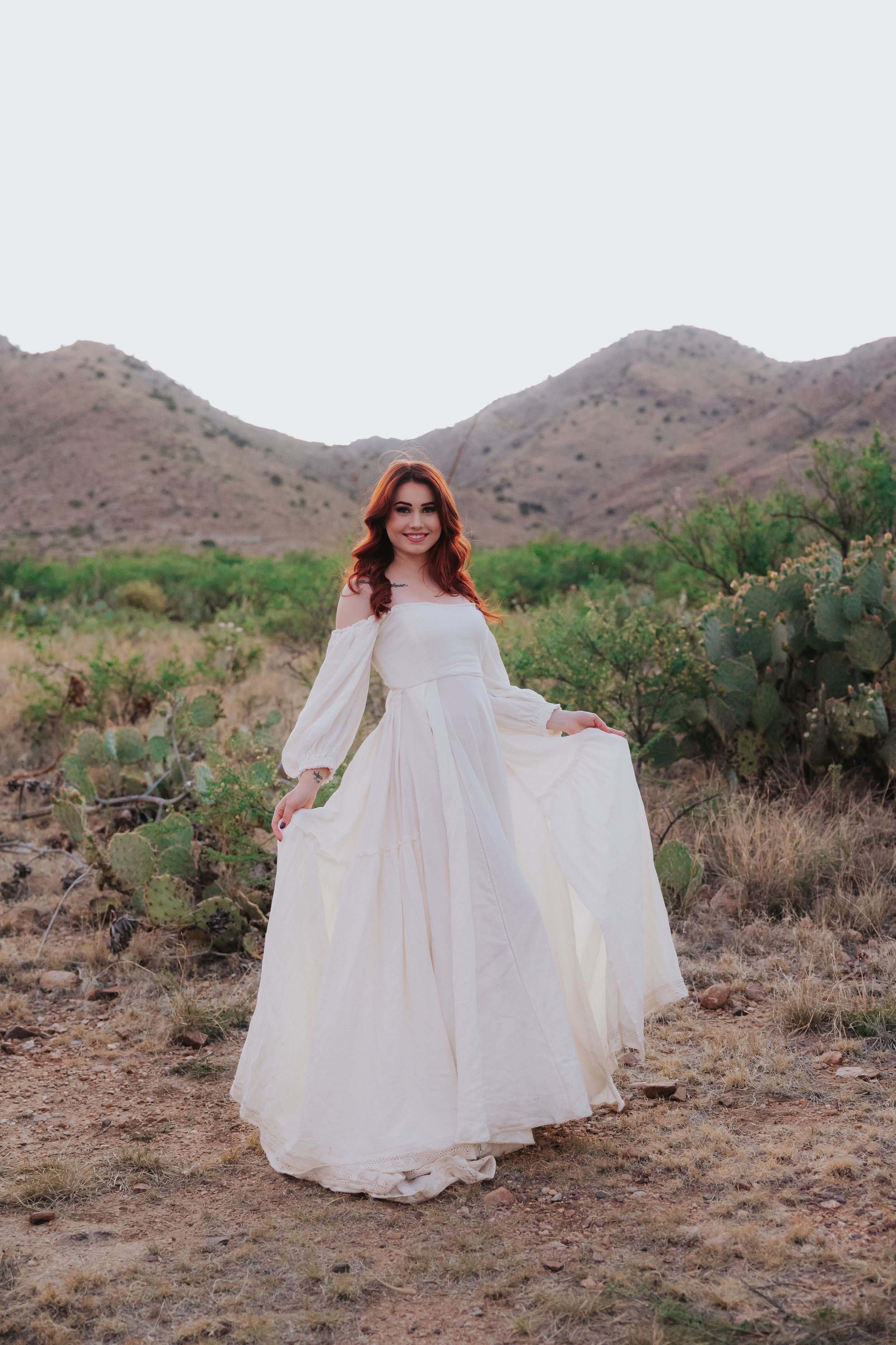 Dramatic white dress movement captured against rugged desert mountain landscape.