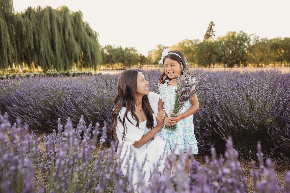 People enjoying a summer day among rows of blooming purple lavender flowers in a scenic garden field.