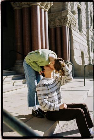 Salt lake city film photoshoot of couple sitting and kissing at city hall