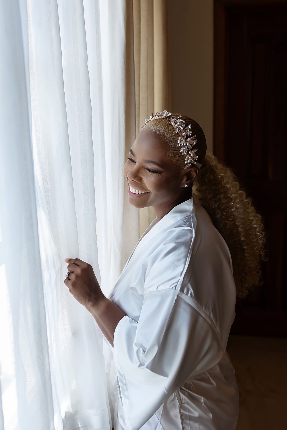 Bride Cherese Ramsey smiling by the window during getting ready at Villa La Joya.