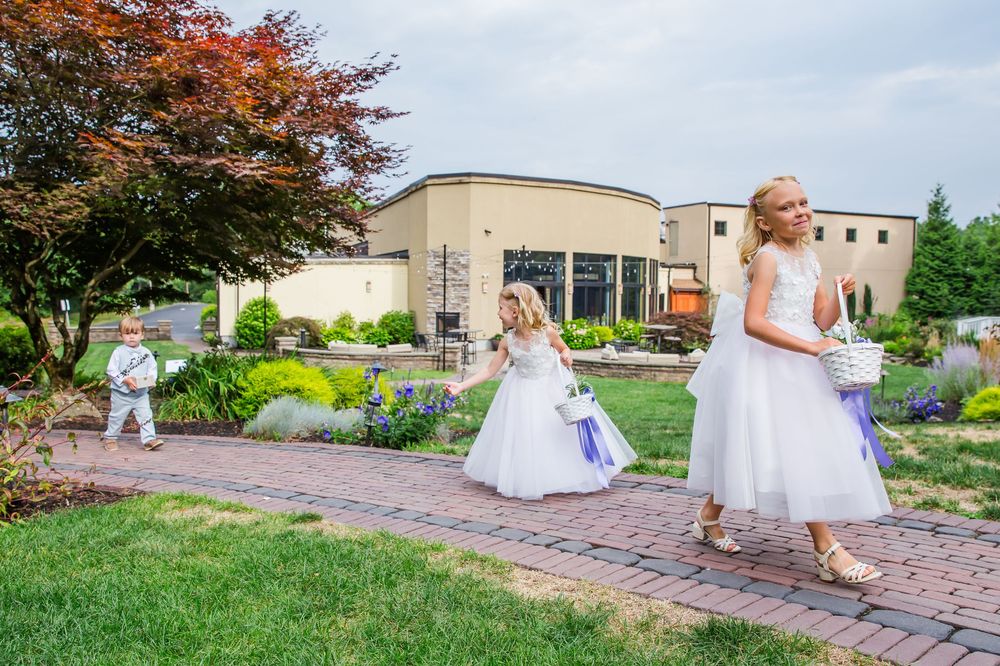 A sequence of photographs showing people in white formal dresses walking along a decorative brick path outside.
