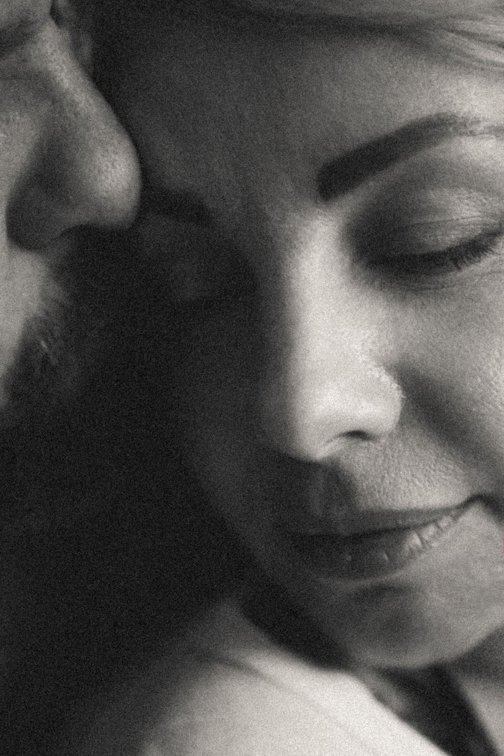 Artistic black and white close-up portrait showing gentle expression and soft lighting.
