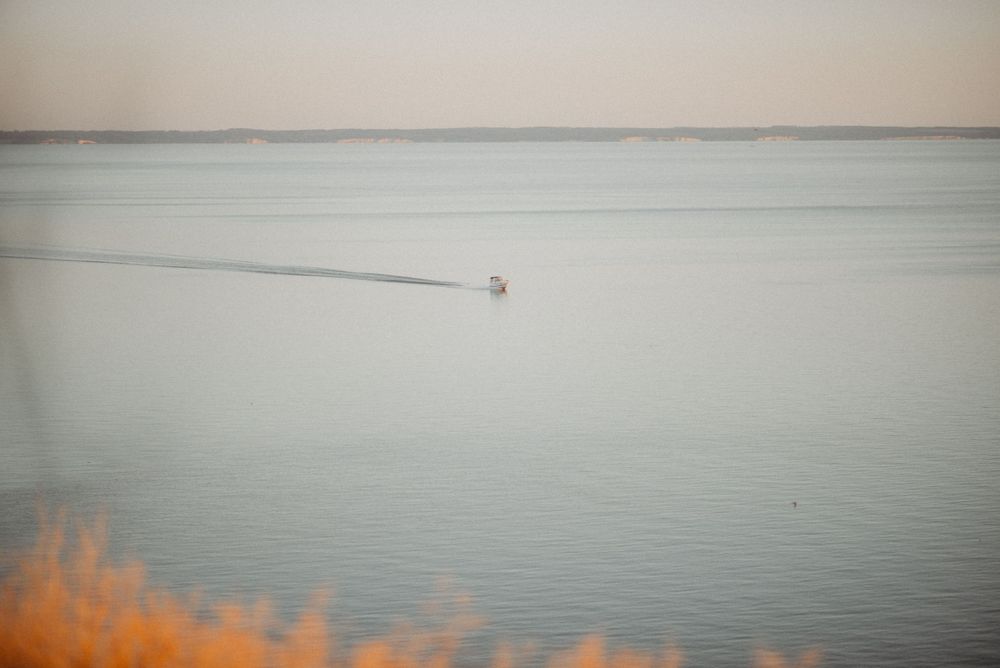 Minimalist seascape with muted tones showing calm waters meeting misty horizon.