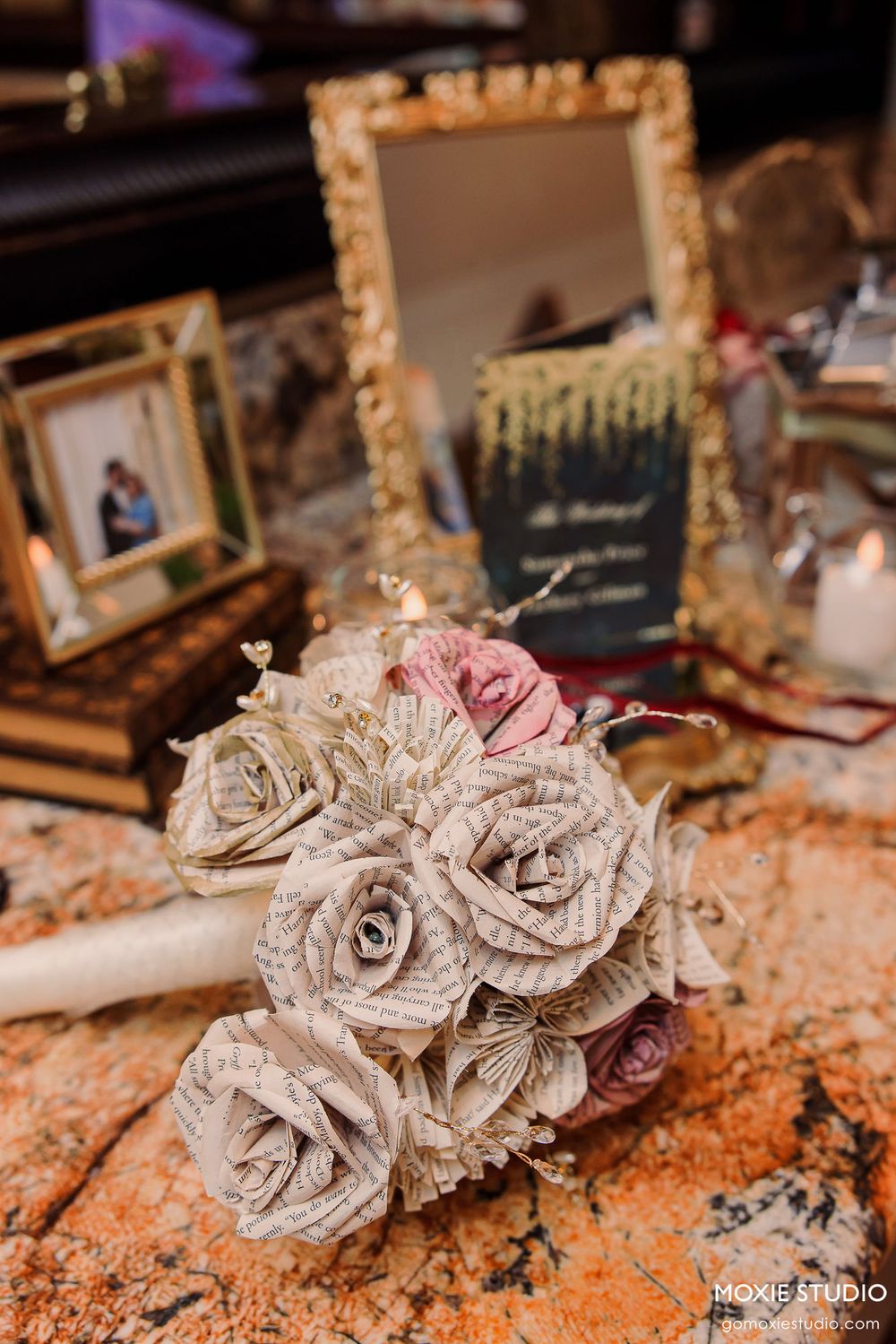 Handcrafted paper roses made from book pages create an elegant vintage wedding decor piece on a rustic surface.