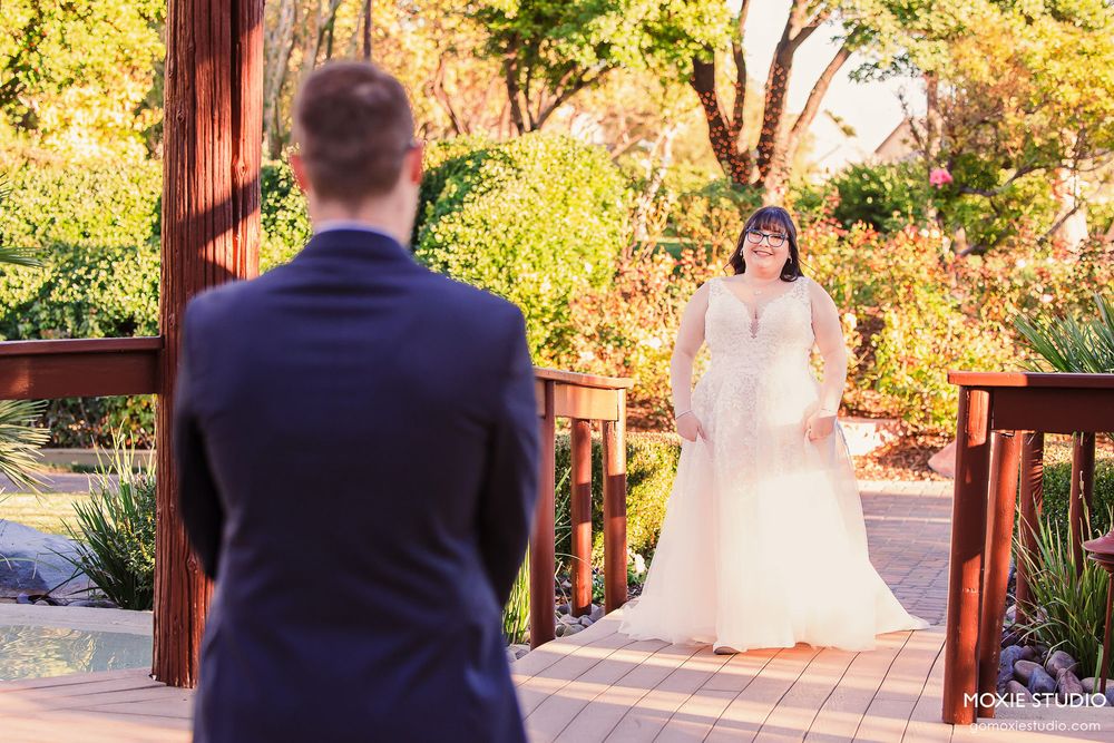 A romantic garden wedding scene with a wooden pergola and golden autumn foliage in the background.