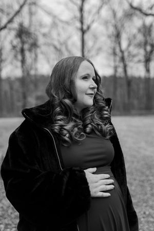 Two people embrace in a black and white photograph showing a tender moment in a natural outdoor setting.