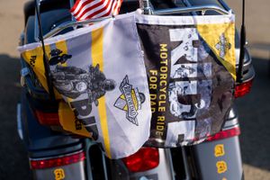 A motorcycle displaying flags, including an American flag and a yellow 'Ride' banner.