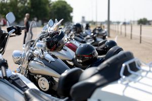Row of parked motorcycles with chrome details gleaming in the sunlight.