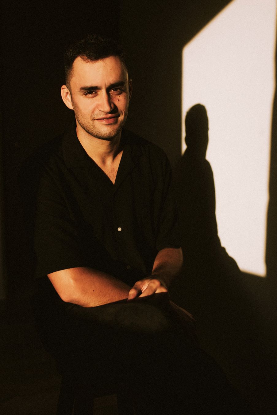 Artistic black and white portrait series showing dramatic shadows and lighting against a dark background.