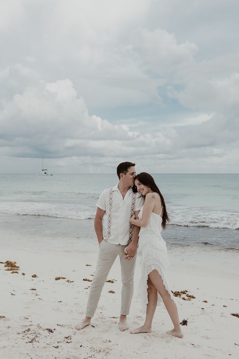 Couple embracing on the beach during a luxury engagement session in Xpu Ha.