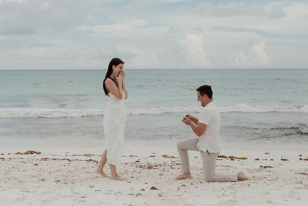 Romantic moment of a man proposing on the white sand beach of Riviera Maya.