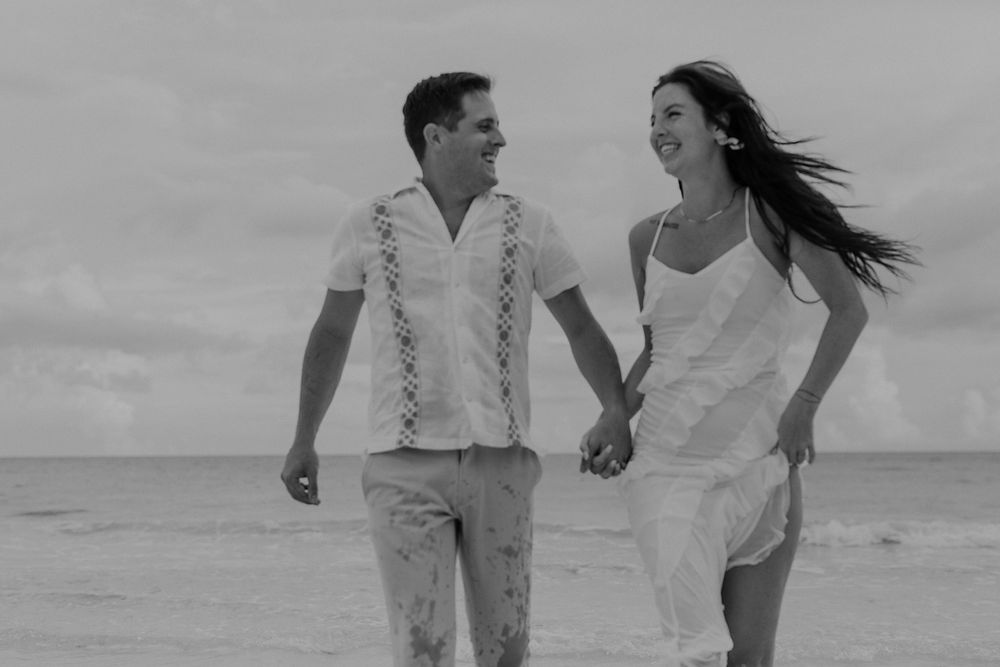 Playful engagement portraits of a couple running along the Caribbean Sea in Xpu Ha.