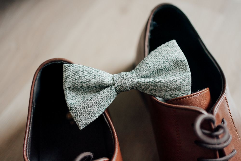 Close-up view of a light gray textured bow tie with delicate pattern details.