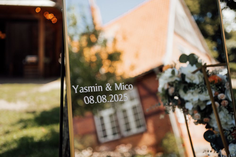 A romantic outdoor wedding venue decorated with string lights, floral arrangements and rustic decor at sunset.