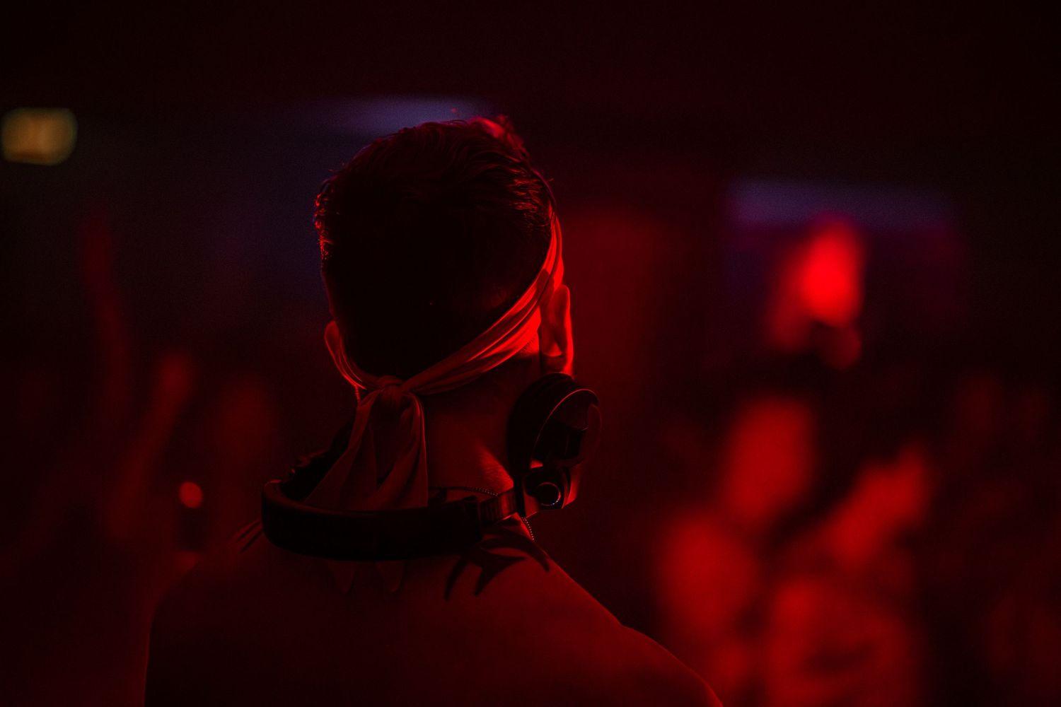 A DJ overlooks the dance floor at Eclipse, a nightlife event at Epiphany Center in Chicago, basked in red lighting