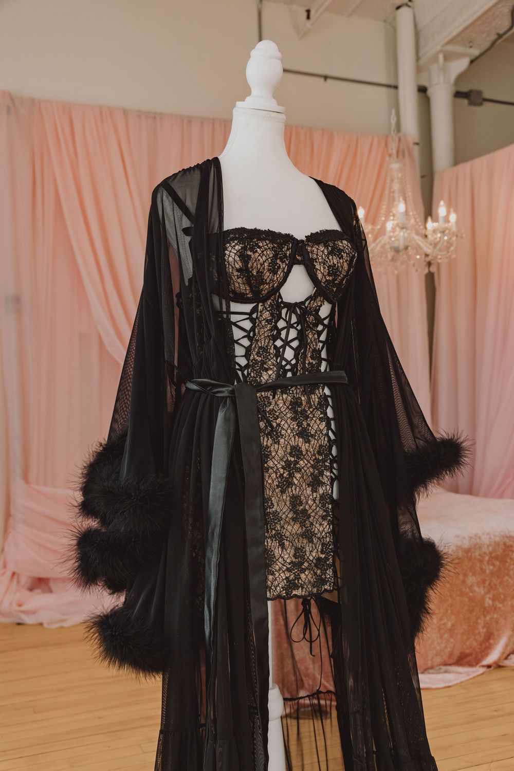 Black sheer feather-trimmed robe and lace lingerie set displayed on white mannequin.