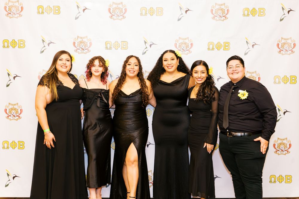 Group photo of attendees wearing black formal attire at an awards ceremony.