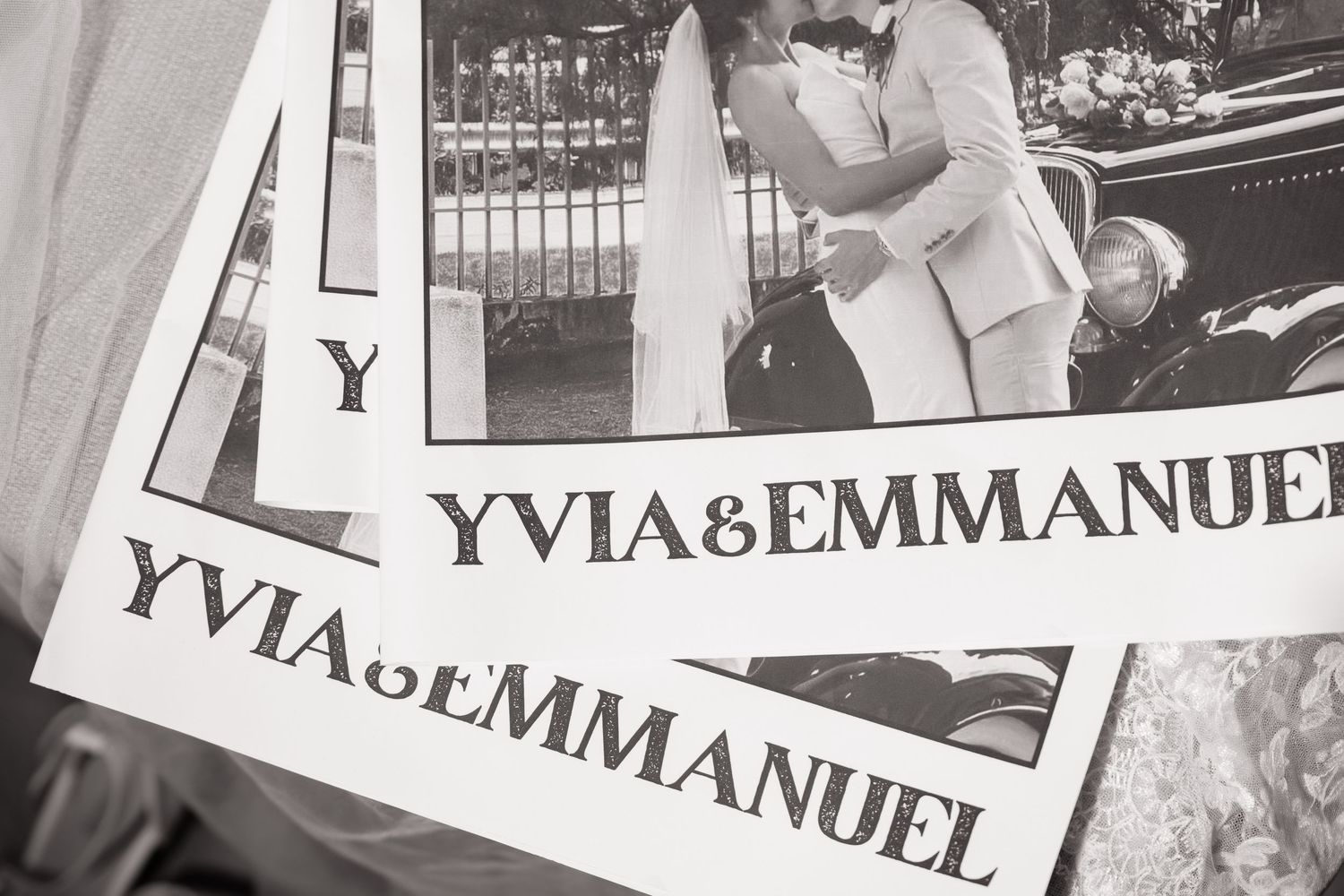 Black and white close-up of Yvia and Emmanuel wedding newspaper with couple photo.