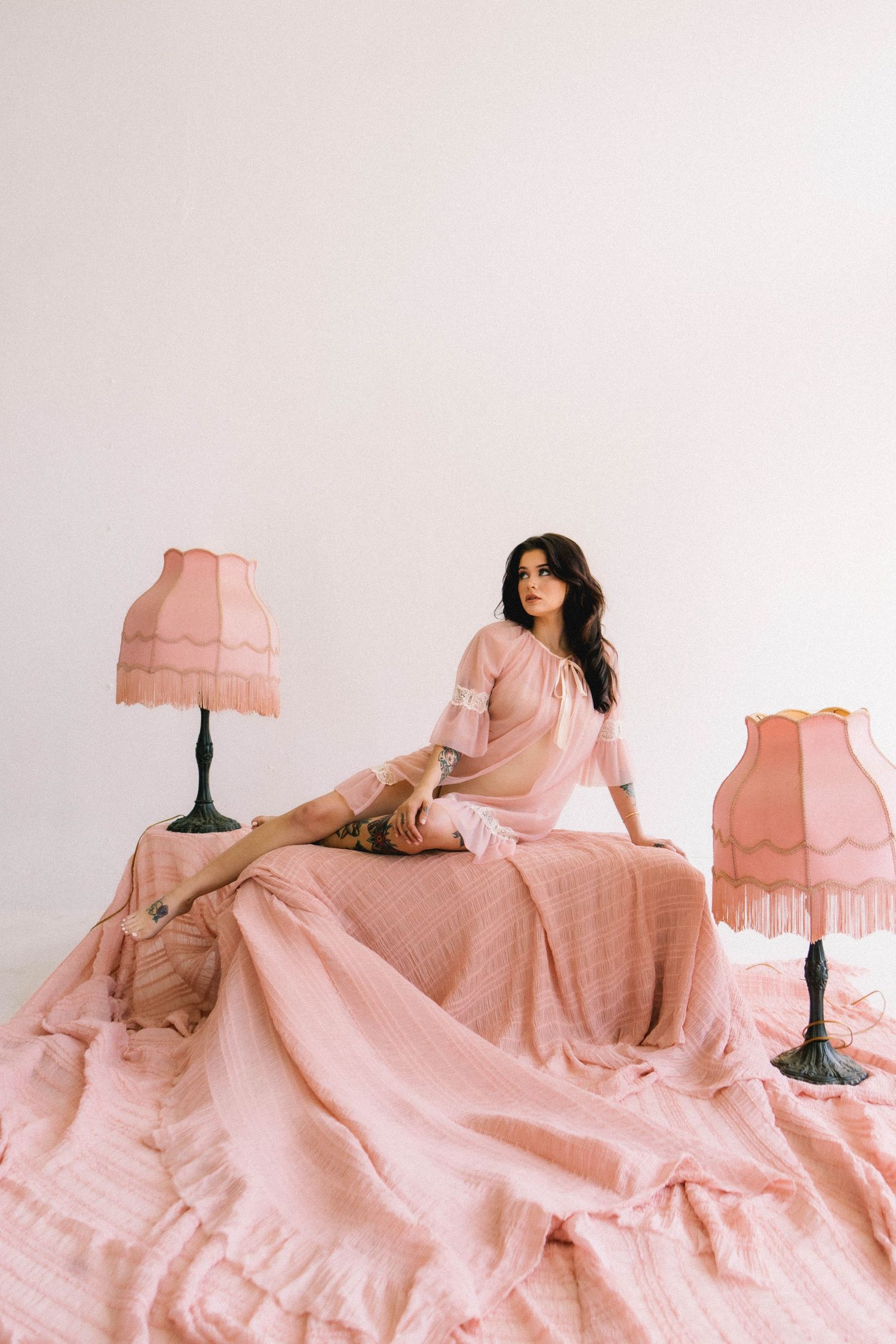Pink vintage lampshades arranged in a flowing composition against white background.