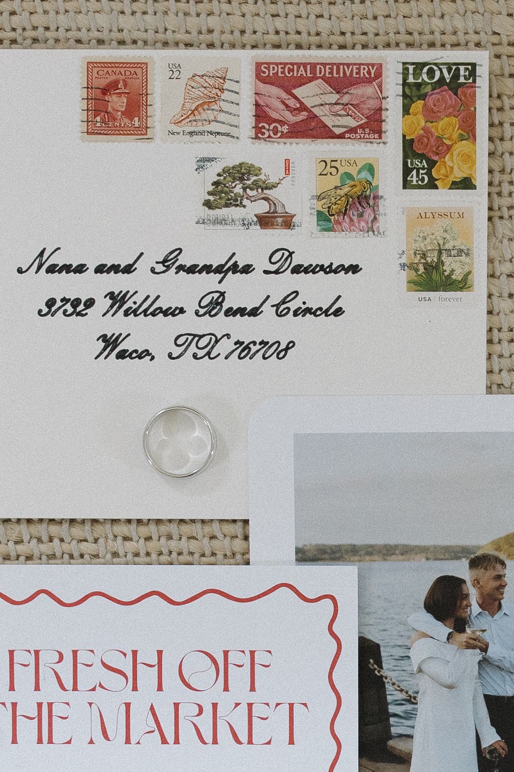 Vintage stamps and wedding invitation details on rustic burlap background.