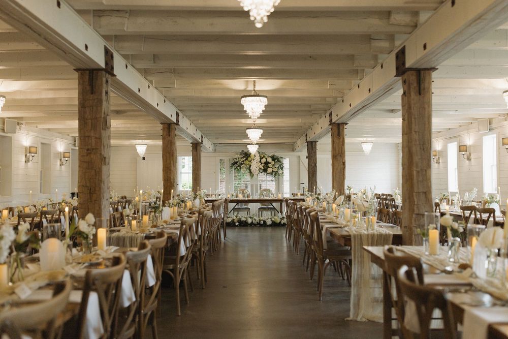 Elegant reception hall with crystal chandeliers and exposed beams creating romantic ambiance.
