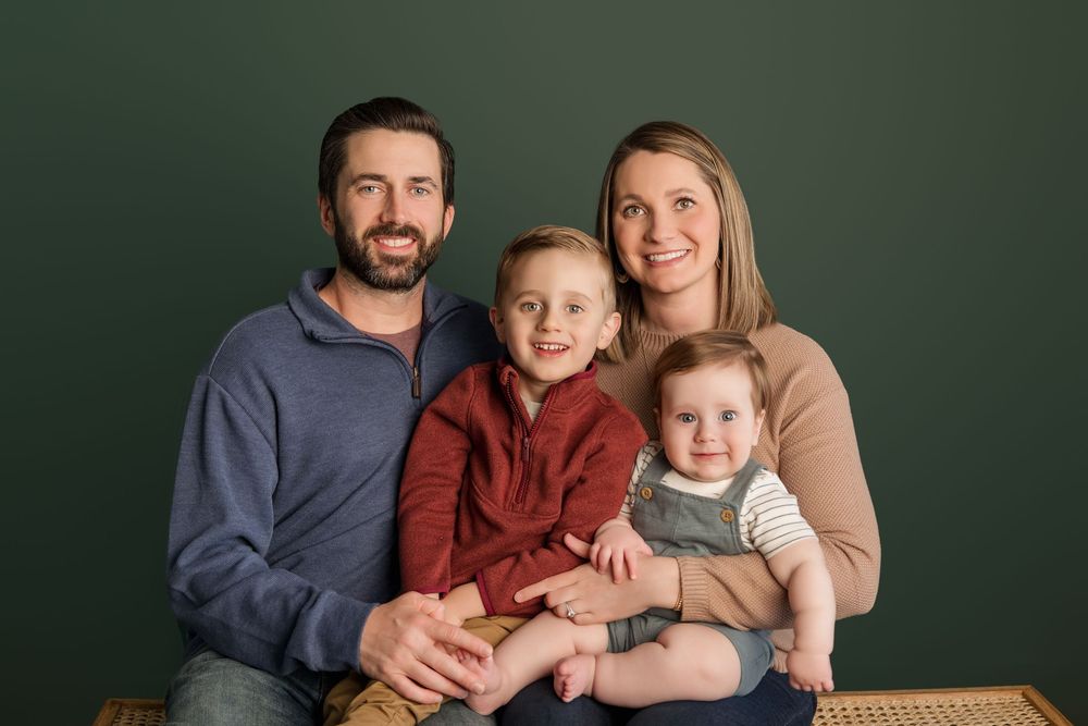 Professional family portrait series against dark green backdrop showing warm embraces in coordinating casual outfits.