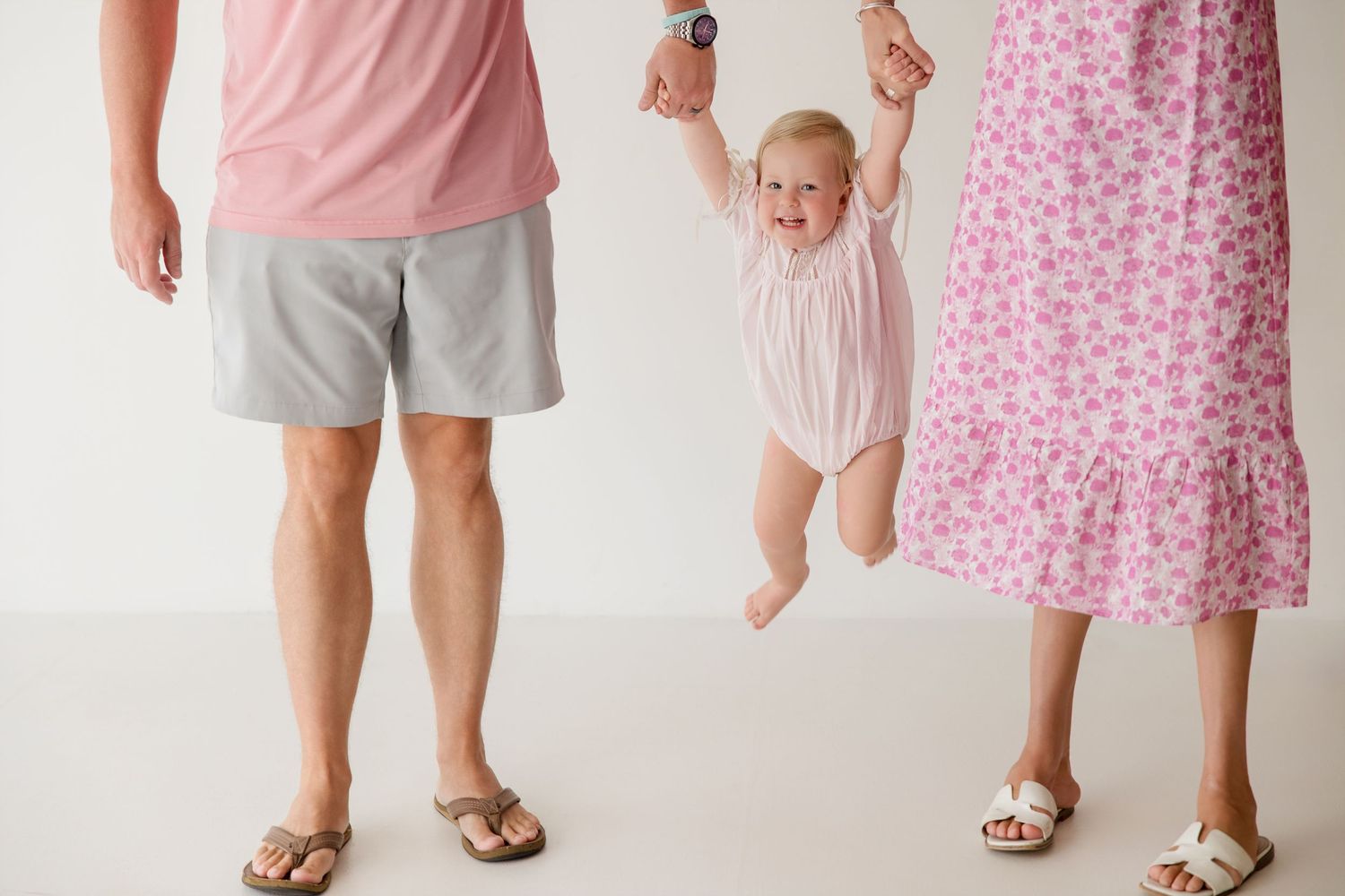 Three people wearing light colors and patterns stand close together in a candid moment.