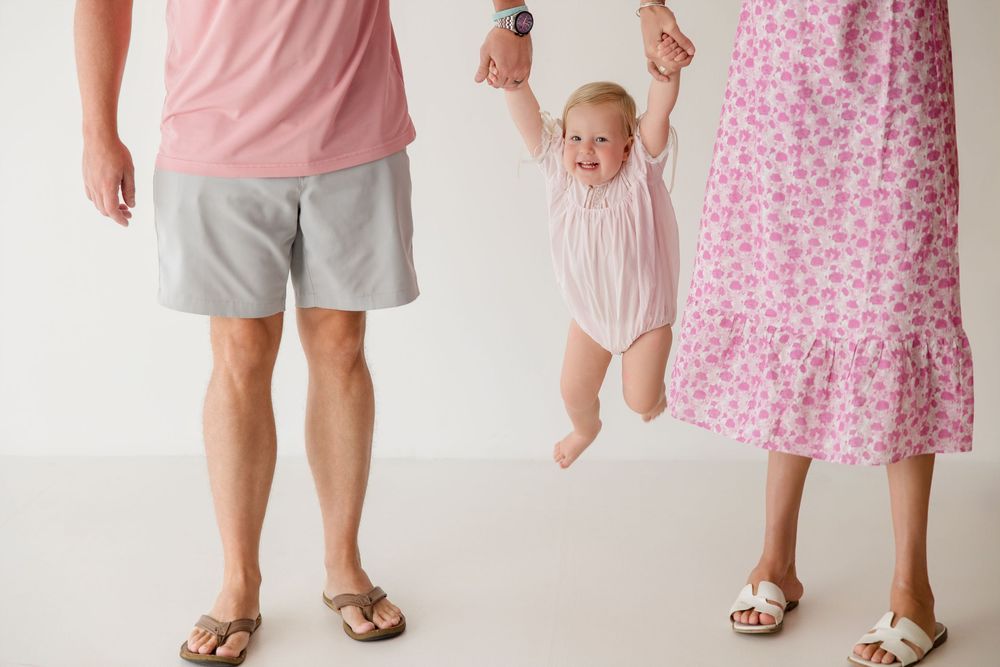 Three people wearing light colors and patterns stand close together in a candid moment.