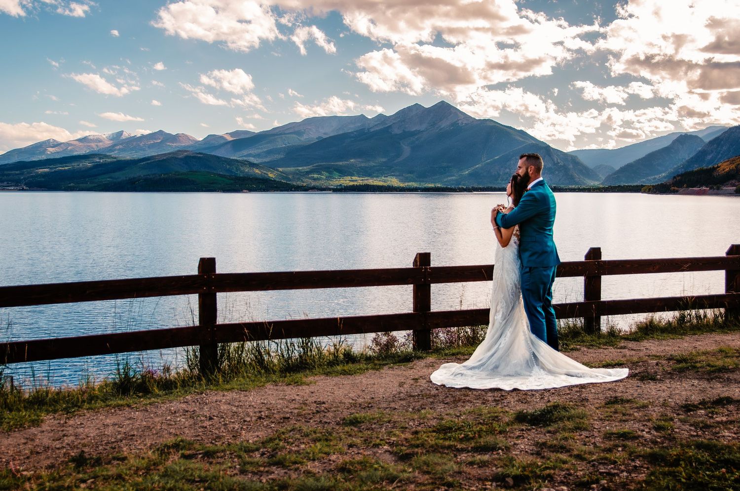 Bride and groom posing for their wedding photos in from of he Dillon Reservoir