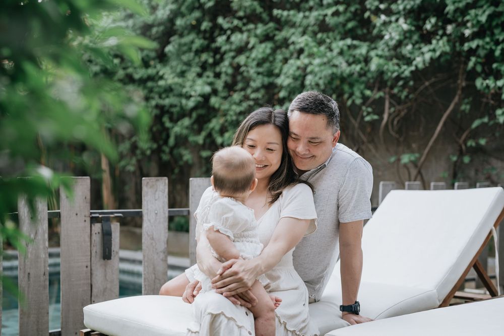 A family enjoys quality time together on outdoor furniture in a garden setting.
