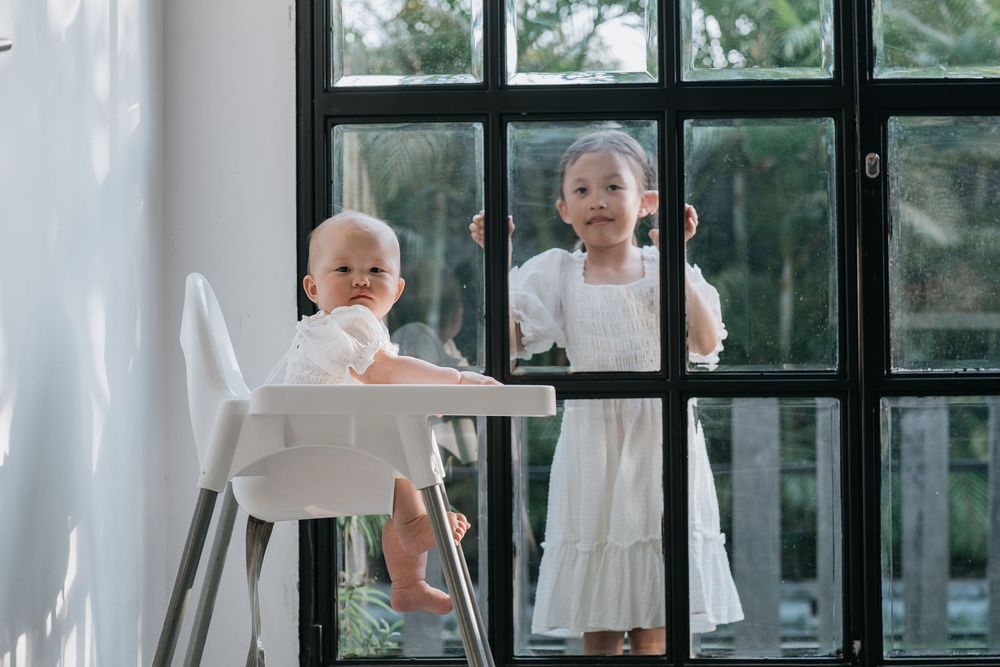 Modern interior scene with large windows and white furnishings in natural light.