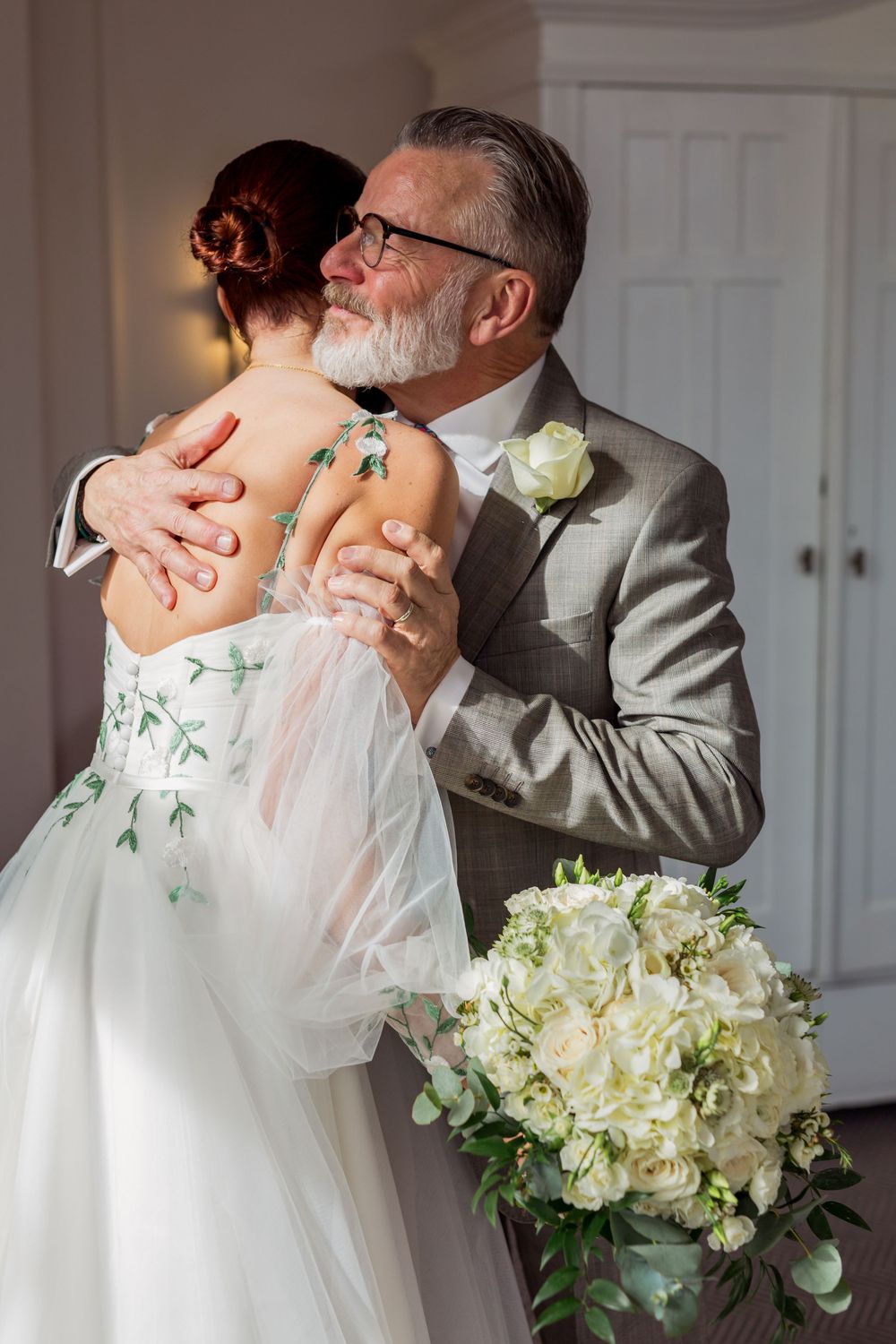 A romantic wedding moment captured in a triptych showing a couple dancing with white floral bouquet and grey suit.