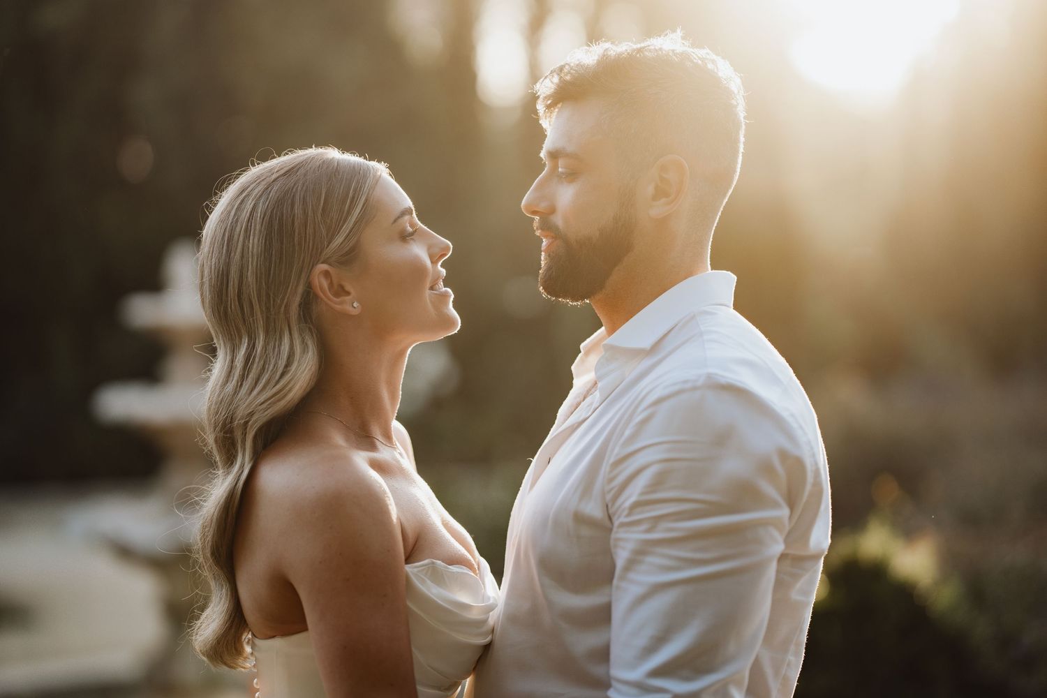 wedding couple cuddle look at eyes with love at sunset